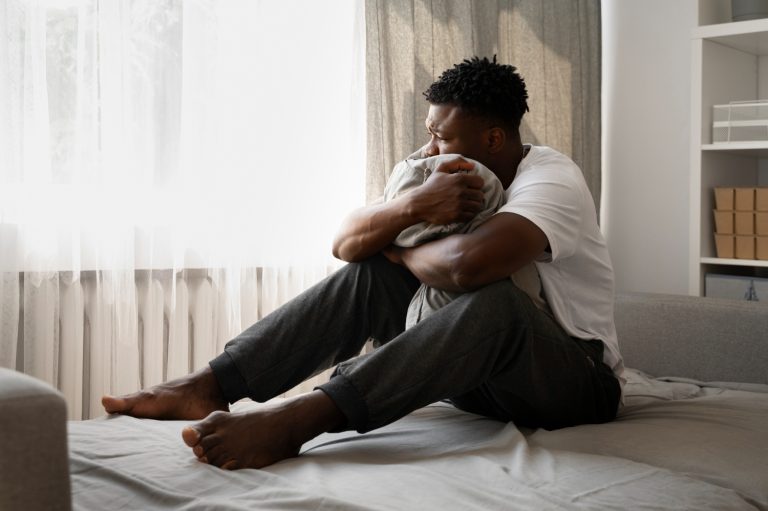 A person sitting alone in quiet reflection, representing emotional healing after betrayal and sex addiction in a relationship.
